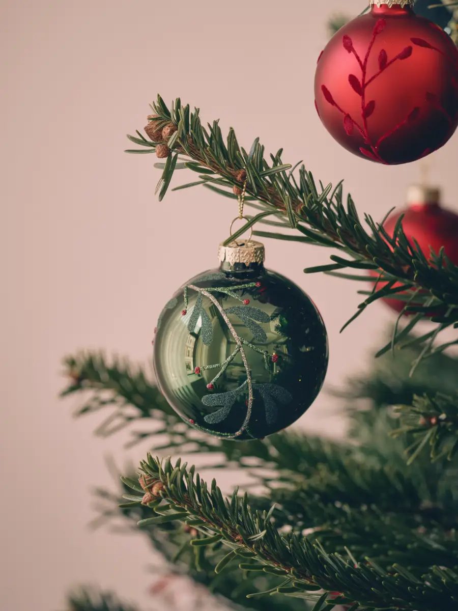 Boule de Noël verte avec un motif branche de gui ton sur ton