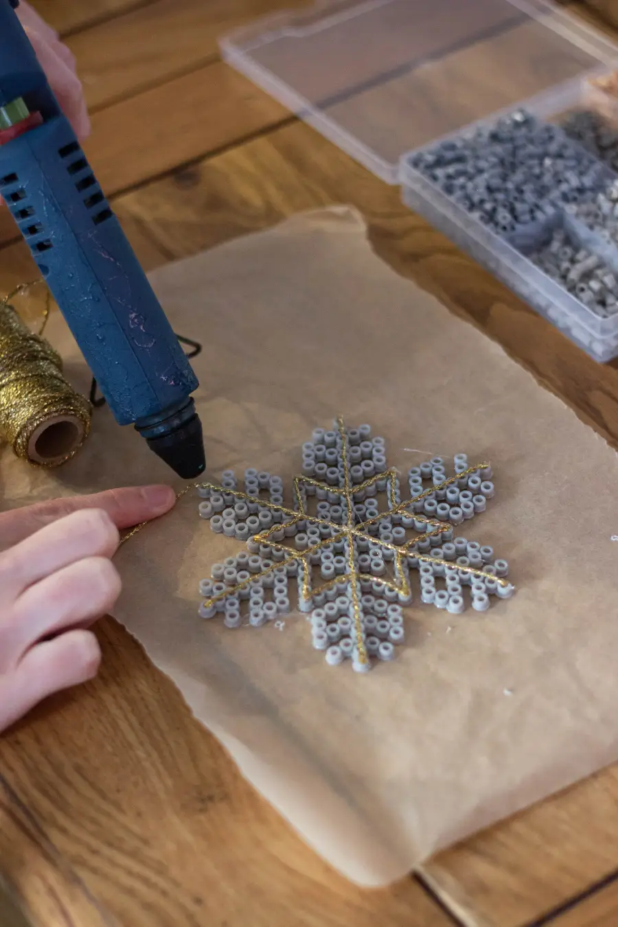 Coller le fil doré sur le flocon en perles à repasser à la colle chaude pour créer un motif