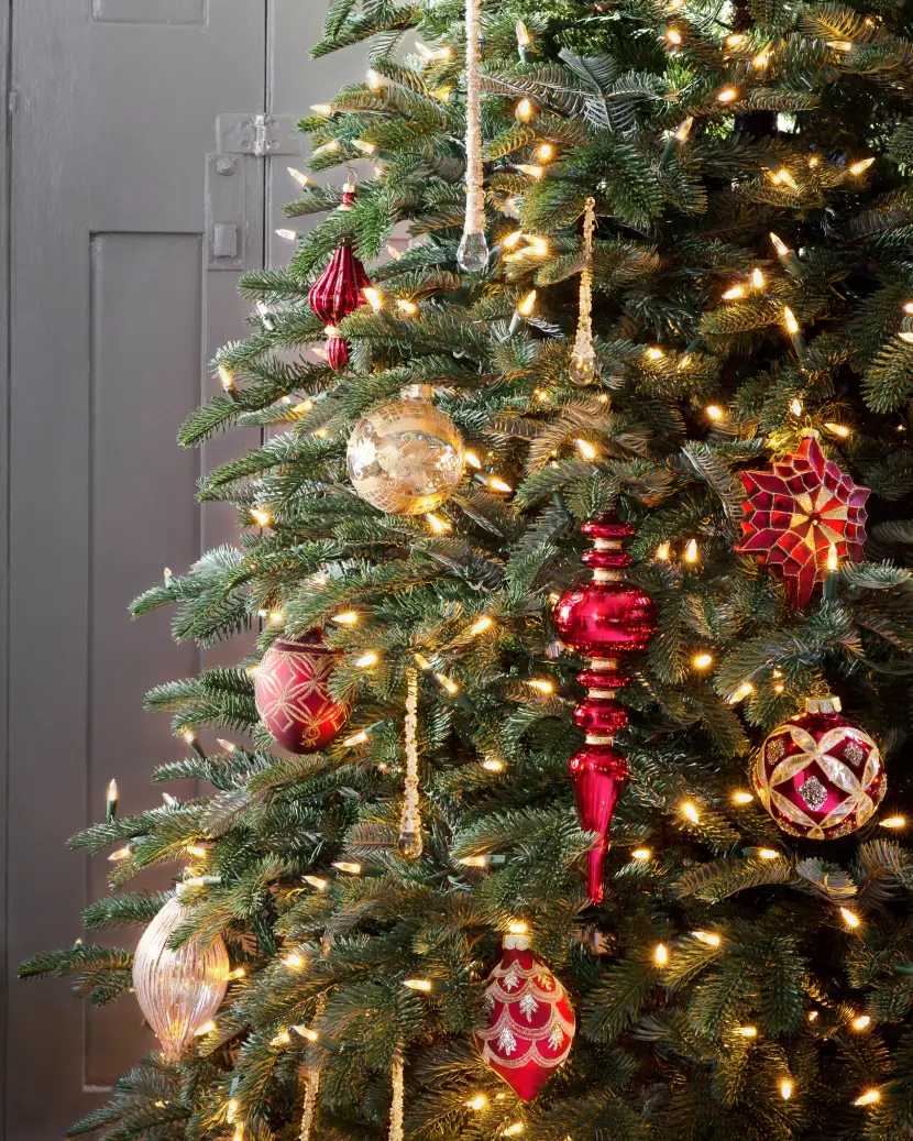 Décoration de sapin de Noël traditionnelle avec guirlande lumineuse et ornements rouges et dorés