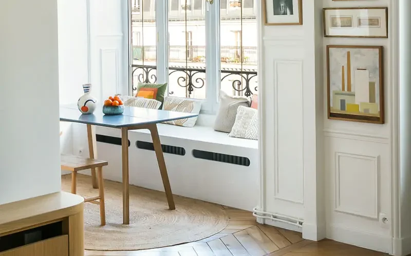 Radiateur caché dans un coffrage blanc faisant également office de banc.