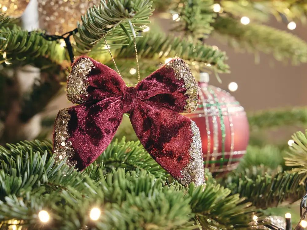 Décoration de Noël avec des nœuds en velours bordeaux et paillettes dorées